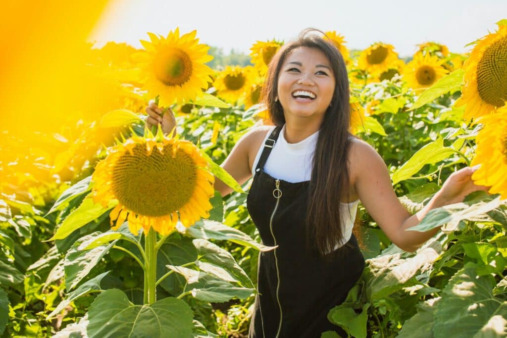 woman laughing in a field of sunflowers